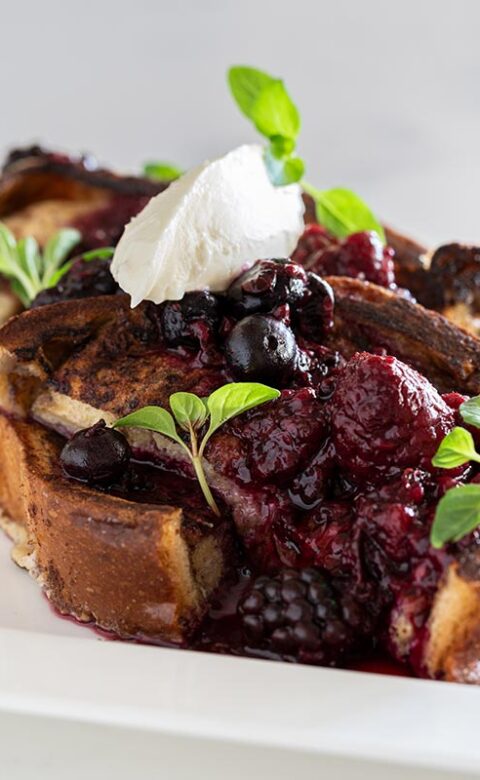 dessert topped with a black- and red berry sauce