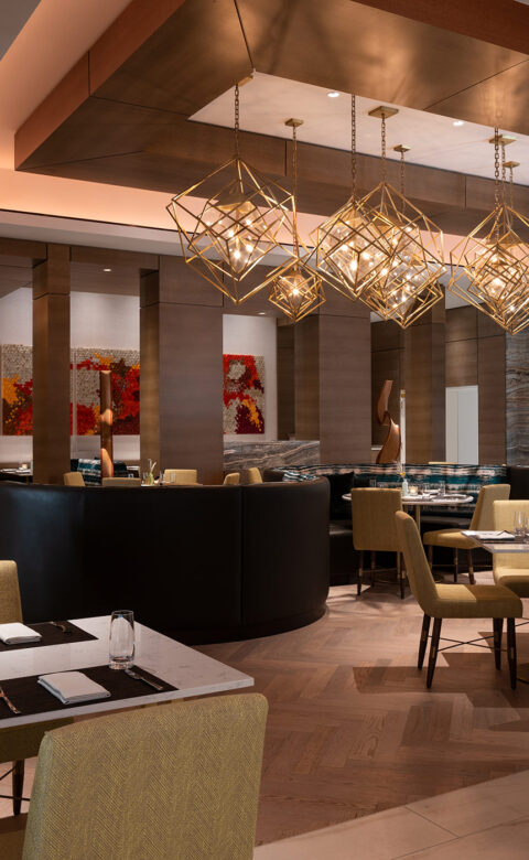 room filled with tables set for dinner and padded chairs