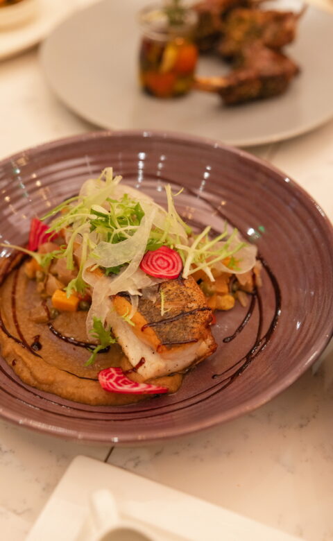 Pan-seared fish served with vegetables and purée in a bowl